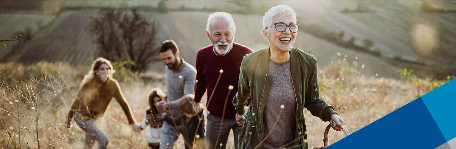 happy senior woman leading her family to perfect picnic place