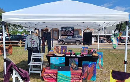 Miniature art canvases on display at a farmer's market.