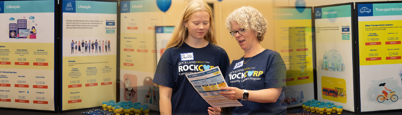 Julie training a volunteer at Credit For Life Fair.