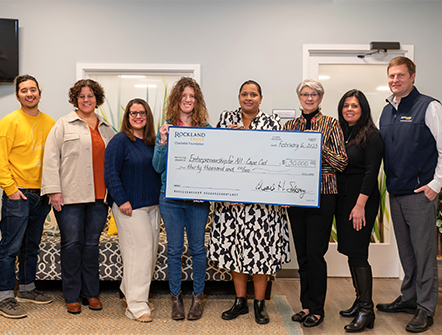 Members of Community Mentoring Team posing with their giant seventy-five thousand dollar check from Rockland Trust's Charitable Foundation.