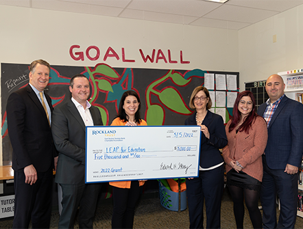 Members of LEAP for Education posing with their giant five thousand dollar check from Rockland Trust's Charitable Foundation.